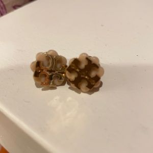 Beige and gold tone Tory Burch studs.